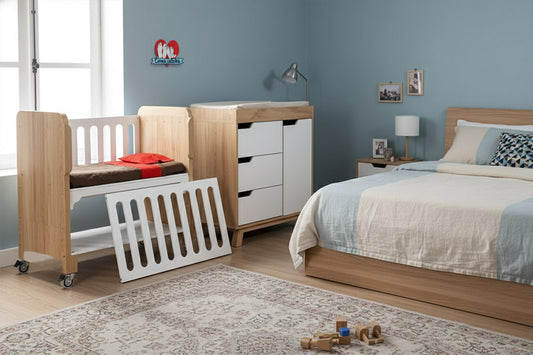 Cambiador y cuna colecho en habitación infantil, solución práctica para organizar pañales y ropa.