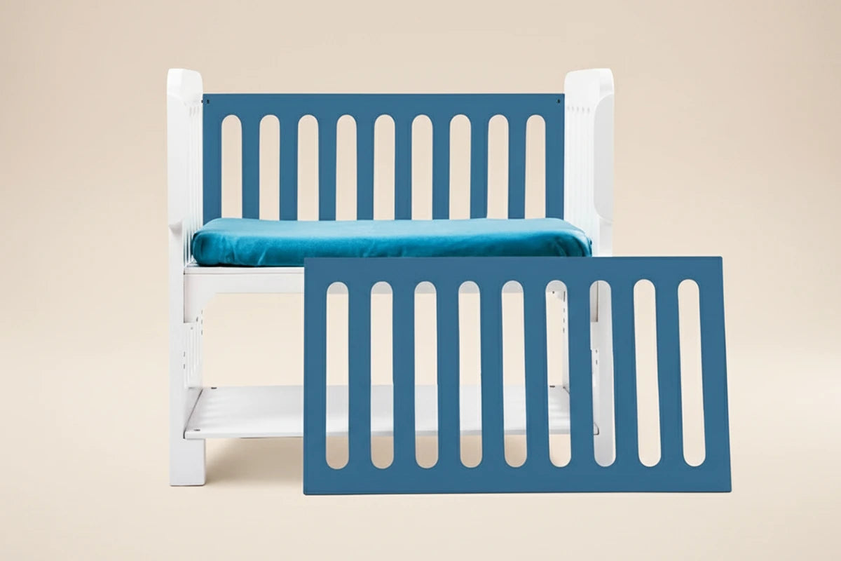 Esta imagen presenta la Cuna Colecho 4 en 1 Modelo Destellos en color azul, un mueble multifuncional diseñado en México para dormir al bebé seguro y cerquita de mamá y papá. Su estructura se adapta al crecimiento del bebé y funciona como colecho, cuna tradicional, escritorio y banca de lectura. Ideal para hogares que buscan practicidad, estabilidad y diseño. Fondo rosa pastel que resalta el color de la cuna y mantiene un estilo profesional de catálogo.