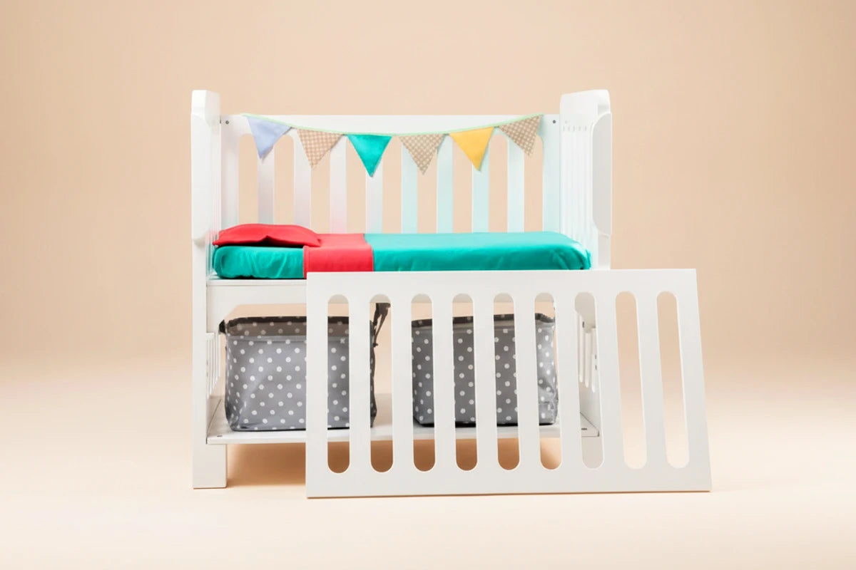 Cuna Colecho 4 en 1 Modelo Destellos en su versión Blanca. Cuna segura, funcional y diseñada para dormir al bebé cerquita de los padres, con aberturas en sus cuatro lados, tamaño compacto y base resistente. Puede usarse como colecho, cunita tradicional, escritorio y banca de lectura.